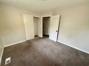 Unfurnished bedroom with carpet and a closet