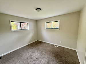 Carpeted empty room with baseboards