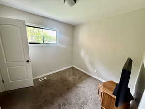 Carpeted empty room with baseboards