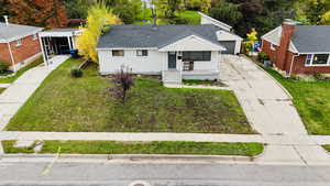 Bungalow-style home with a front lawn, driveway, and brick siding