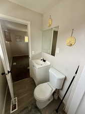 Half bathroom with dark wood-style flooring and vanity