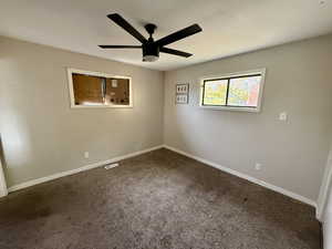 Carpeted empty room with baseboards and ceiling fan