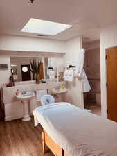 Bedroom featuring wood finished floors and a skylight