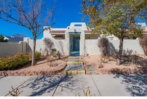 View of front of property featuring a fenced front yard, stucco siding, a tiled roof, and a gate