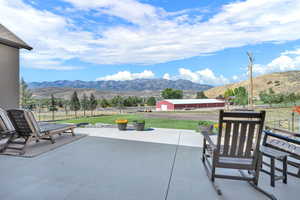 Fenced backyard with a patio, a mountain view, and an outbuilding
