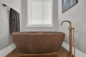 Full bathroom with a freestanding tub and baseboards