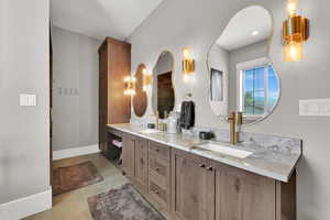Bathroom featuring baseboards and double vanity
