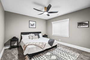 Bedroom featuring dark colored carpet and a ceiling fan