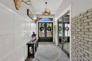 Entrance foyer featuring french doors and a chandelier