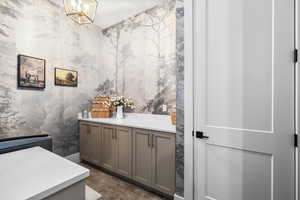 Bathroom with vanity and wallpapered walls