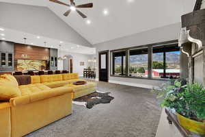 Living room featuring arched walkways, high vaulted ceiling, carpet, a mountain view, and recessed lighting