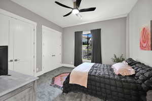 Carpeted bedroom with two closets and ceiling fan
