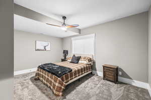 Bedroom featuring carpet, a ceiling fan, and a textured ceiling