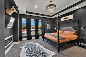 Bedroom featuring a raised ceiling, carpet flooring, a chandelier, and recessed lighting