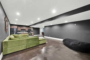 Living area featuring finished concrete flooring and recessed lighting
