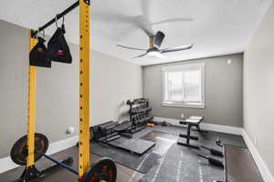 Workout area with a textured ceiling and ceiling fan