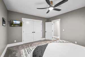 Carpeted bedroom featuring a closet and a ceiling fan