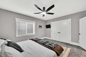 Carpeted bedroom featuring baseboards and a ceiling fan