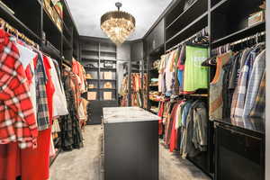 Walk in closet featuring light carpet and a chandelier