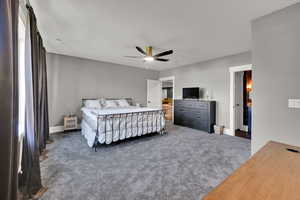Bedroom with carpet flooring, a ceiling fan, and a textured ceiling