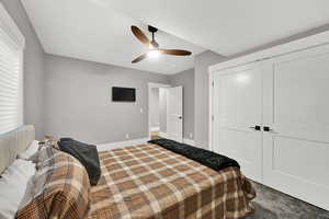 Carpeted bedroom featuring a ceiling fan, a closet, and a textured ceiling