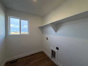 Washroom with washer hookup, dark wood-type flooring, and electric dryer hookup