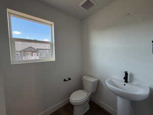 Half bath featuring baseboards and dark wood finished floors