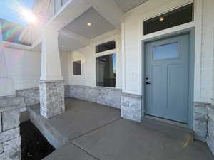 Entrance to property featuring a porch and stone siding