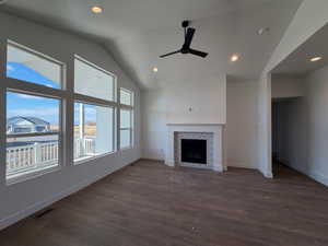 Unfurnished living room with vaulted ceiling, a tile fireplace, ceiling fan, dark wood-type flooring, and recessed lighting