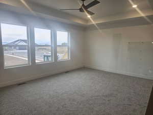 Spare room featuring carpet flooring, a tray ceiling, ceiling fan, and recessed lighting