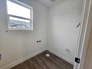 Laundry area with baseboards and dark wood-style flooring