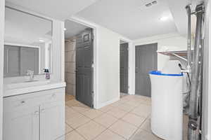 Full bath featuring vanity, light tile patterned floors, a closet, a shower, and recessed lighting