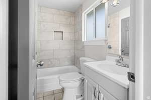 Bathroom featuring vanity, light tile patterned flooring, and tub / shower combination