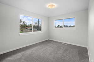 Spare room featuring carpet flooring and baseboards