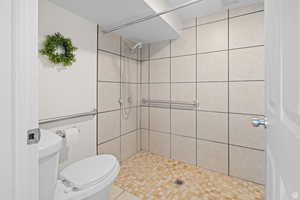 Bathroom featuring a shower stall and light tile patterned flooring
