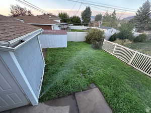 Fenced backyard featuring a shed
