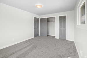 Unfurnished bedroom with carpet and a closet
