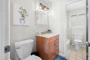 Full bath featuring light tile patterned floors, vanity, and bathing tub / shower combination