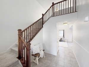 Stairs with a high ceiling and tile patterned flooring
