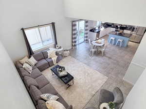Living room featuring a towering ceiling and light tile patterned floors