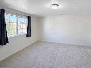 Primary bedroom featuring new carpet, a large walk-in closet, and an attached bathroom.