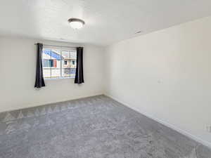 Primary bedroom featuring new carpet, a large walk-in closet, and an attached bathroom.