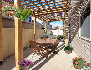 Fenced backyard with a patio, outdoor dining area, and a pergola