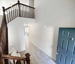 Entryway featuring light tile patterned floors and a towering ceiling