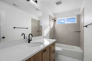 Bathroom featuring vanity, shower / tub combination, and light marble finish flooring