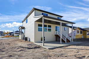 Back of property featuring a residential view, covered porch, and stairs