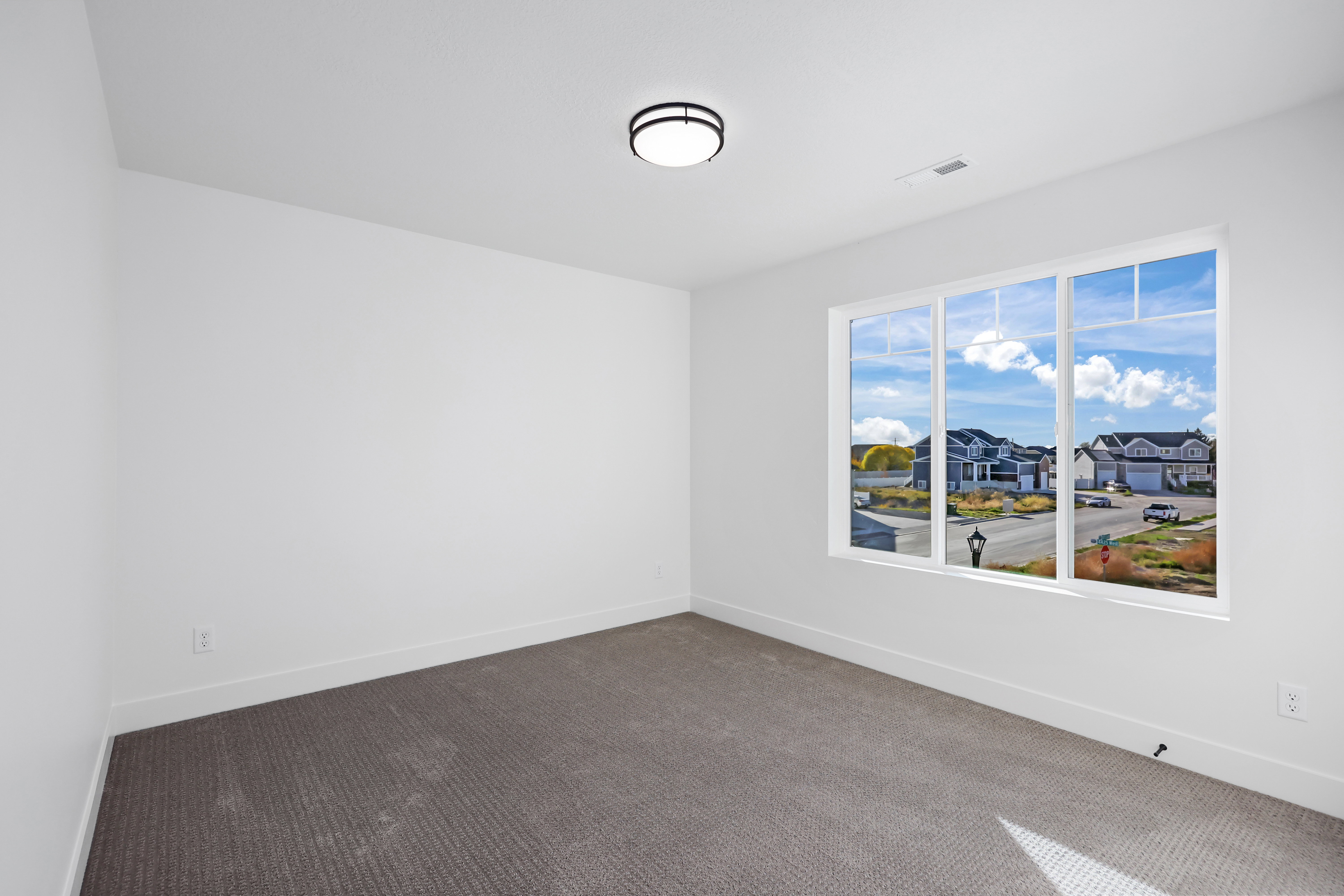 Carpeted empty room with baseboards and a residential view
