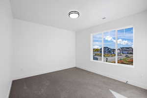 Carpeted empty room with baseboards and a residential view