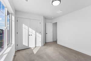 Unfurnished bedroom with carpet and a closet