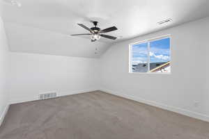 Bonus room featuring carpet flooring, lofted ceiling, a textured ceiling, and ceiling fan